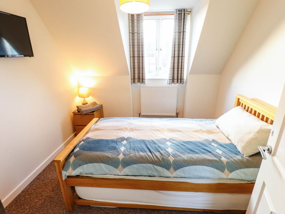 A bedroom with a bed and a television at Beach Lodge