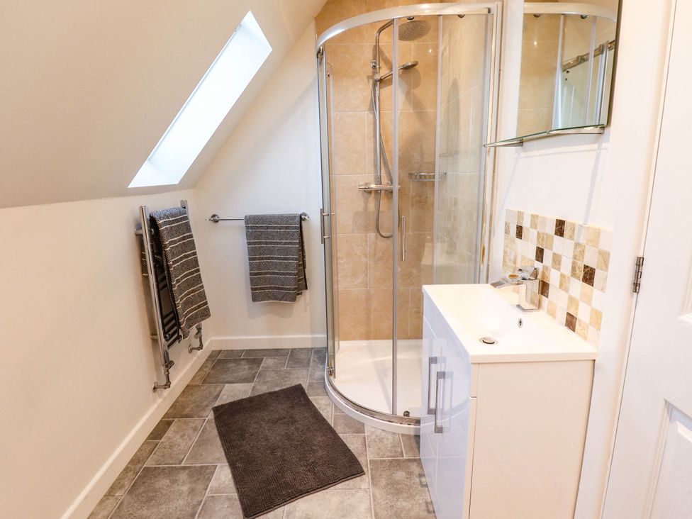 A bathroom with a shower, sink, and towels at Beach Lodge 