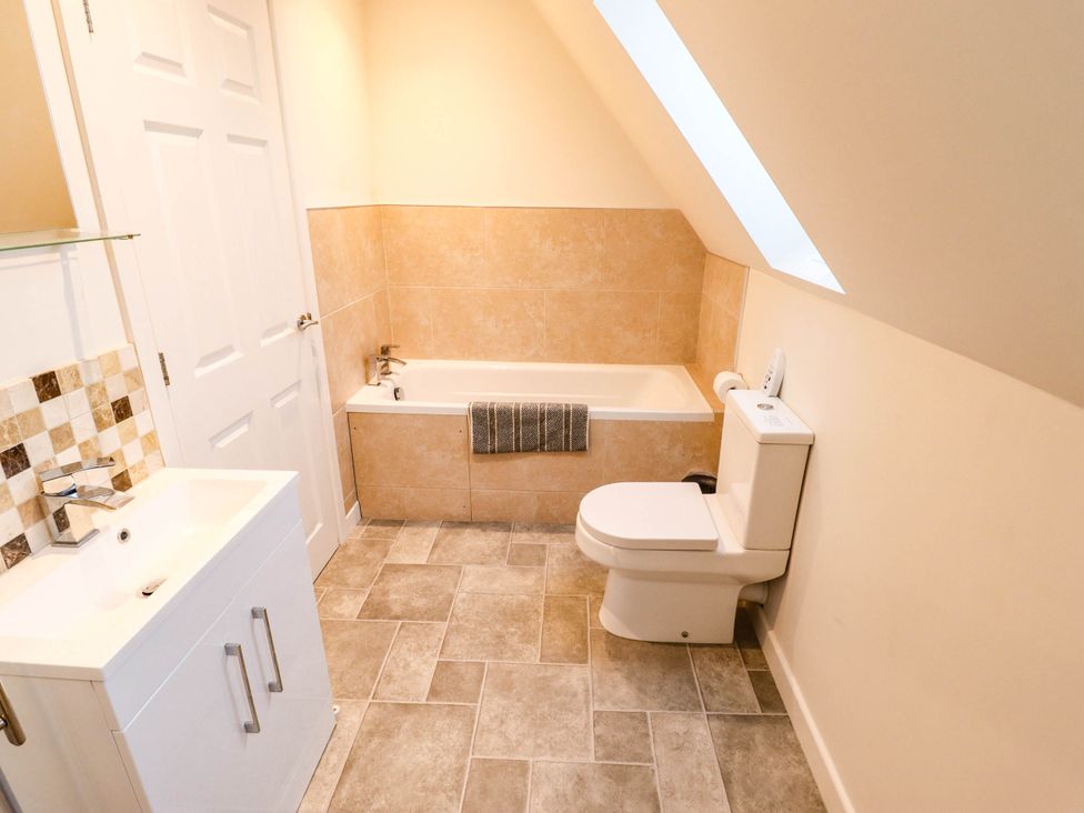 A bathroom with a bathtub, a toilet, and a sink at Beach Lodge