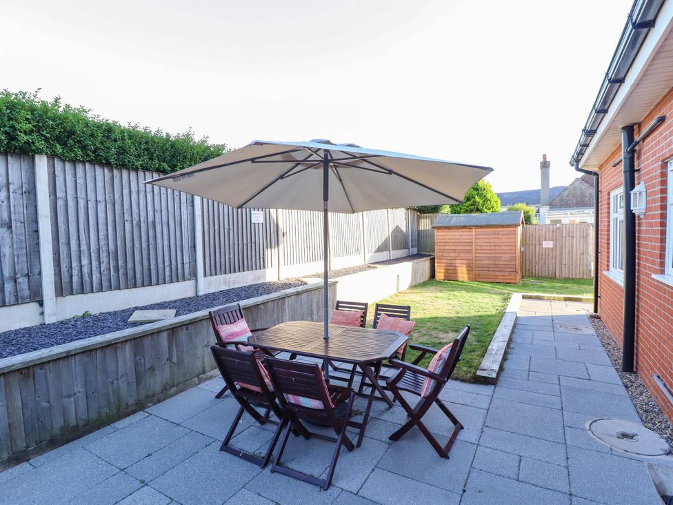 A garden with furniture and an umbrella at Beach Lodge