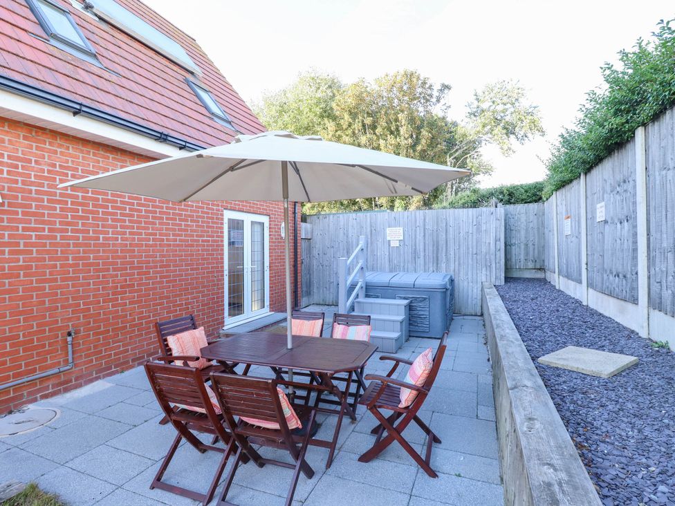 A garden with a table, chairs, and an umbrella at Beach Lodge