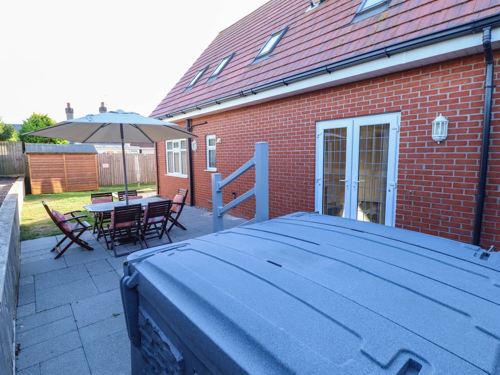A patio area with a table and chairs under an umbrella at Beach Lodge
