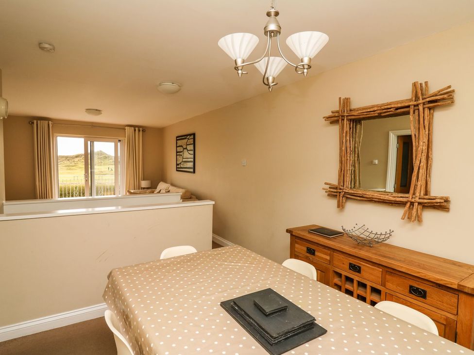 A dining room with a table and chairs at Ty'r Heulwen in Aberdovey