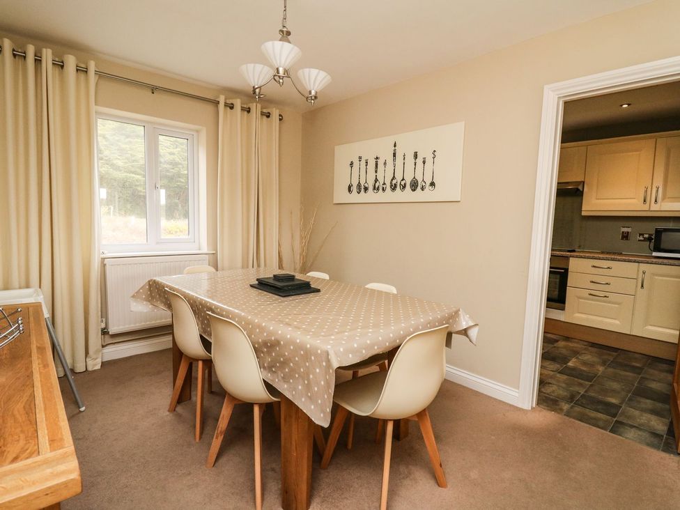 A dining room with a table and chairs at Ty'r Heulwen in Aberdovey