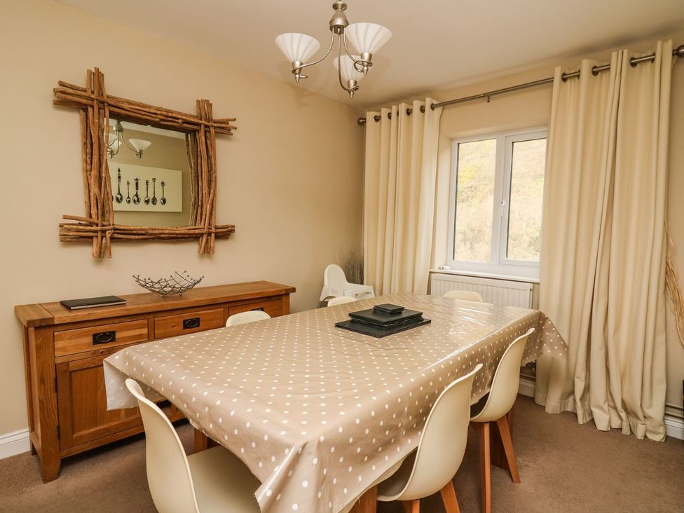 A dining room with a table and chairs at Ty'r Heulwen in Aberdovey