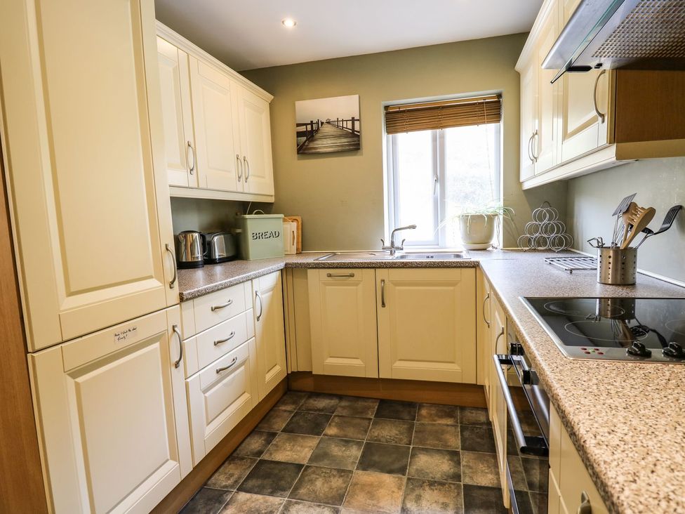 A kitchen with cabinets and a sink at Ty'r Heulwen in Aberdovey