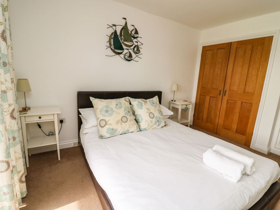 A bedroom with a bed and bedside tables at Ty'r Heulwen Aberdovey