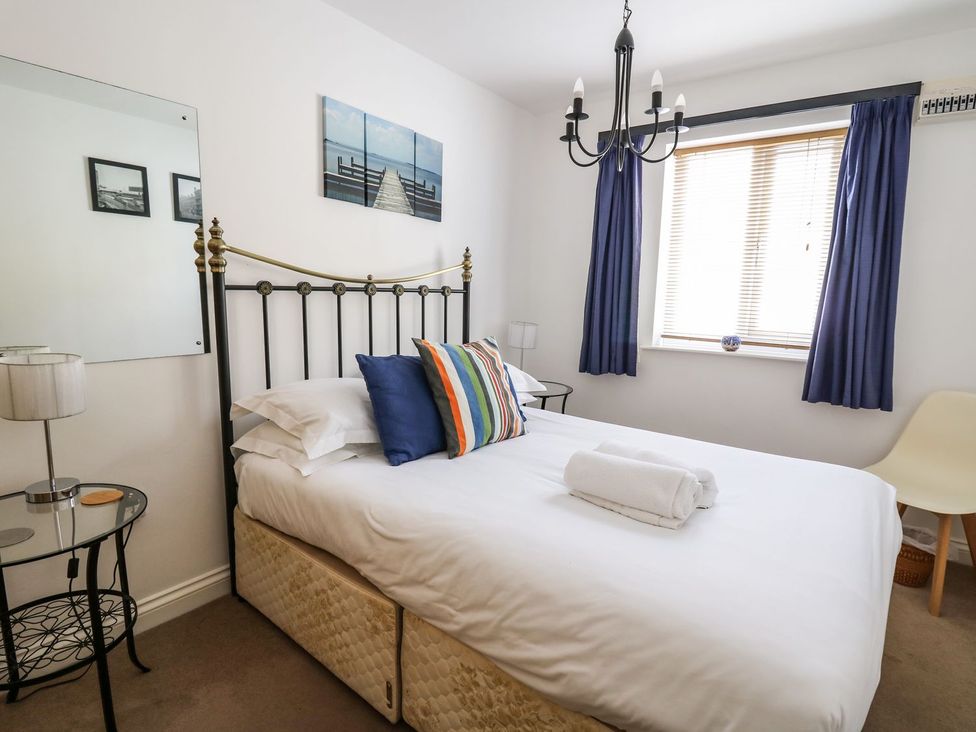 A bedroom with a bed and a bedside table at Ty'r Heulwen in Aberdovey