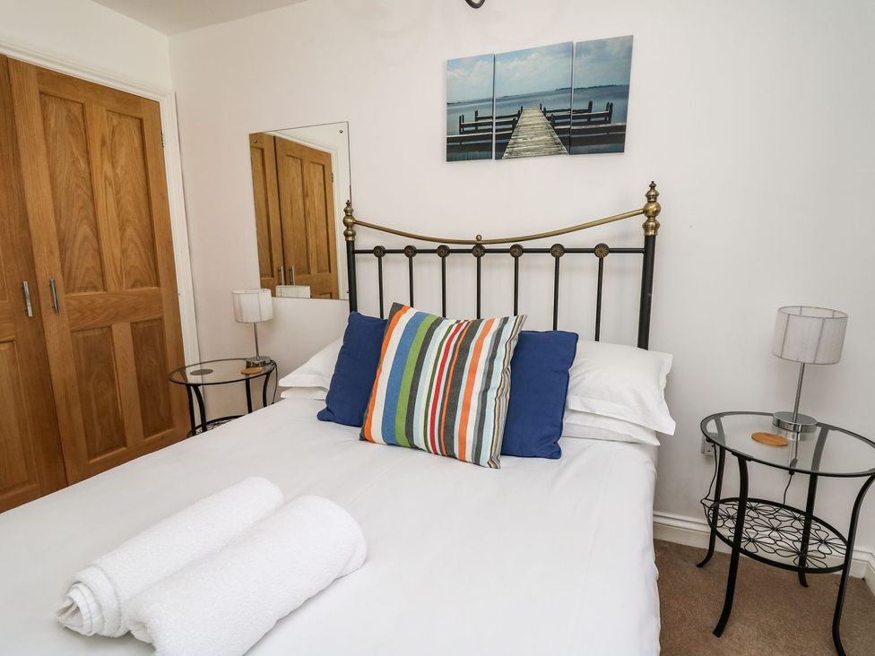 A bedroom with a bed and nightstands at Ty'r Heulwen in Aberdovey