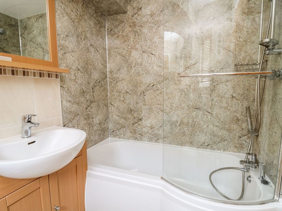 A bathroom with a bathtub and sink at Ty'r Heulwen in Aberdovey