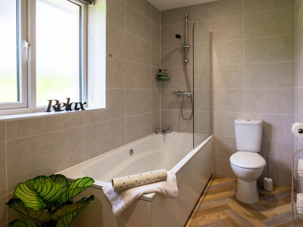 A bathroom with a bathtub and toilet at Bay Bungalow