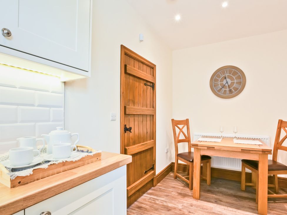 A kitchen with a table and chairs at Hillberry Cottage in Carnforth