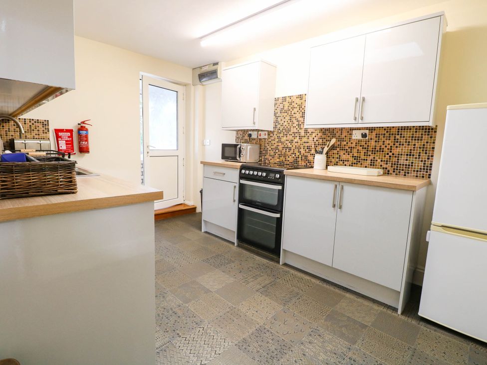 A kitchen with cabinets and appliances at The Mill House Apartment