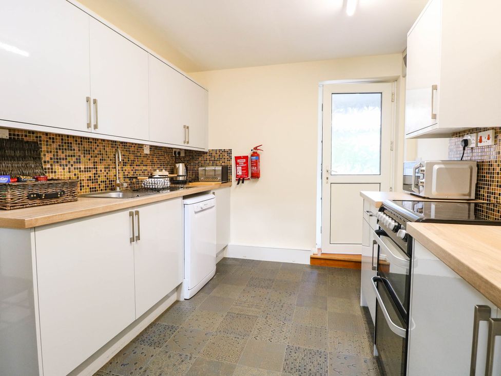 A kitchen with appliances and a door at The Mill House Apartment 