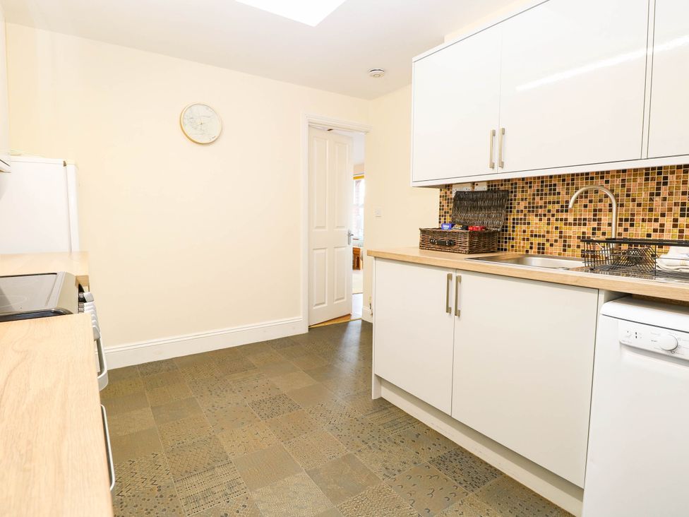 A kitchen with cabinets and appliances at The Mill House Apartment