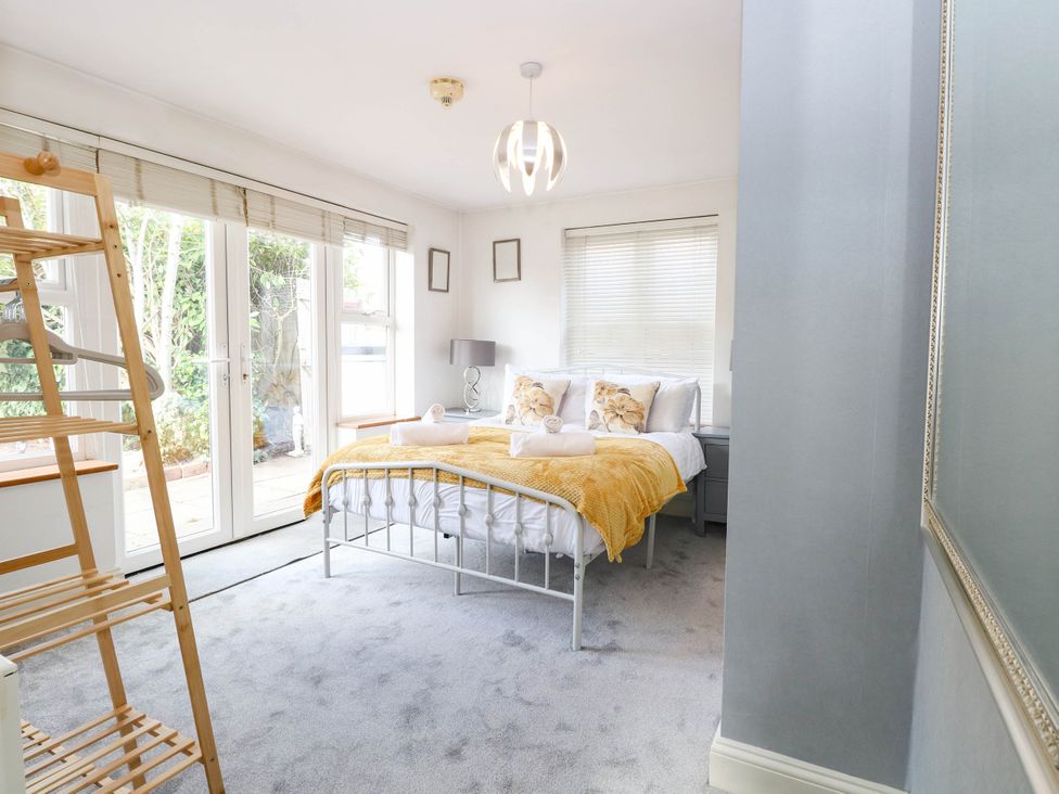 A bedroom with a bed and sliding doors at The Mill House Apartment
