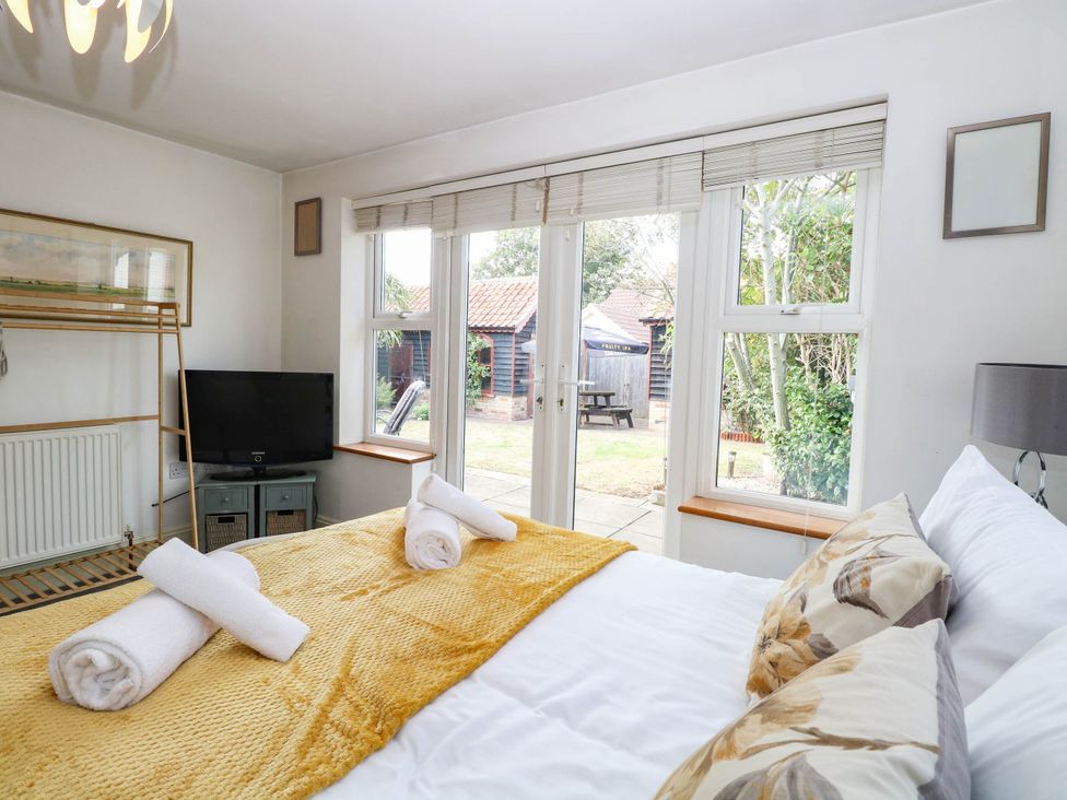 A bedroom with a bed and television at The Mill House Apartment