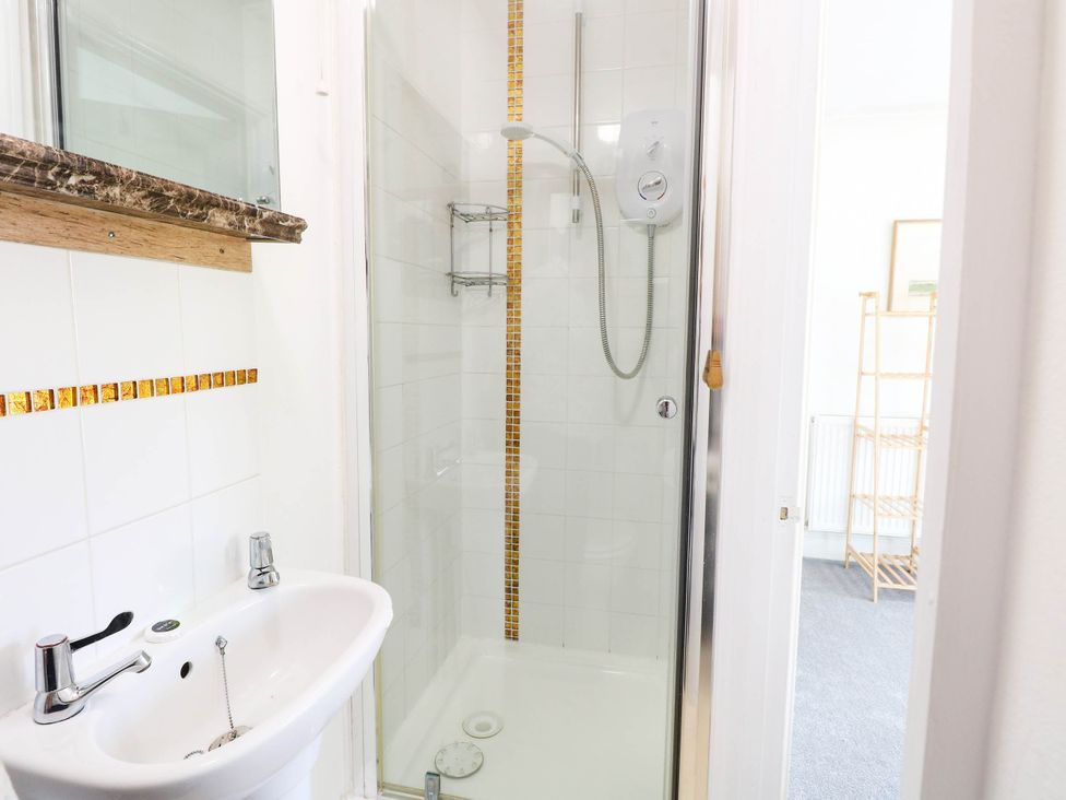 A bathroom with a sink and shower at The Mill House Apartment