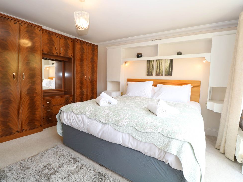 A bedroom with a bed and wardrobe at The Mill House Apartment 