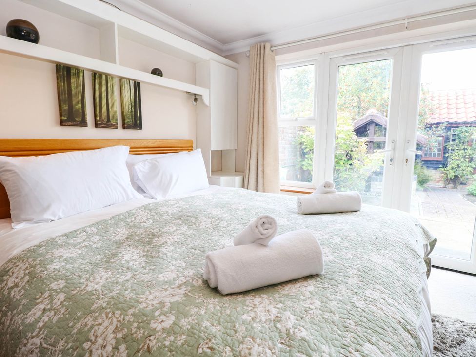 A bedroom with a bed and towels on the covers at The Mill House Apartment 