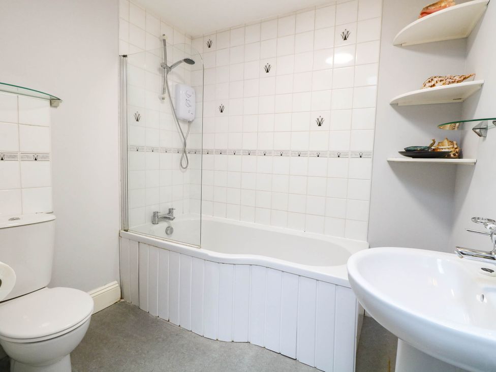 A bathroom with a bathtub and shower unit at The Mill House Apartment in 