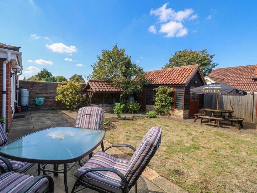 A garden with a patio table and chairs at The Mill House Apartment