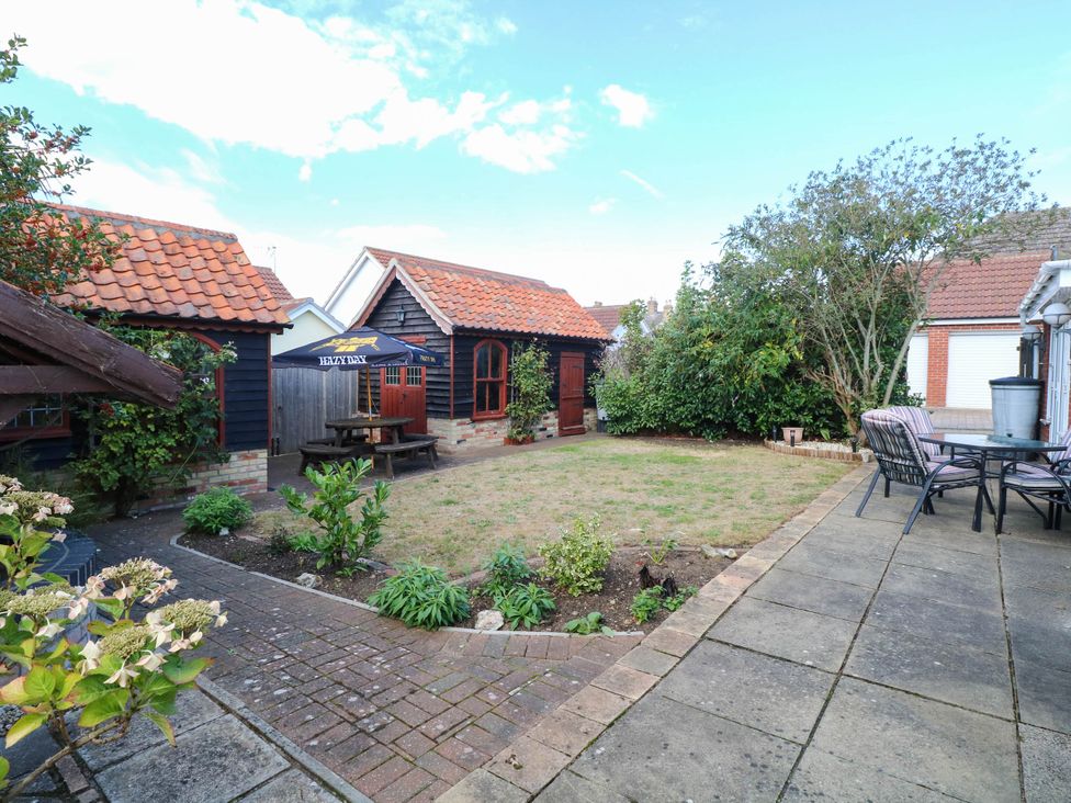 A garden with a shed and seating area at The Mill House Apartment
