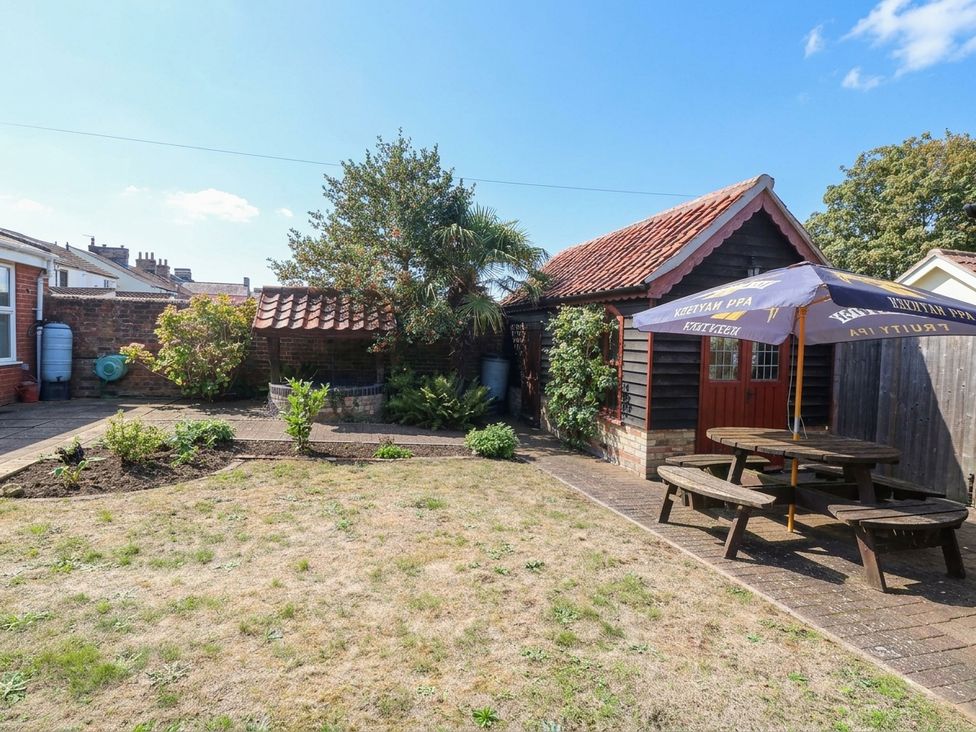 A garden with a shed and seating area at The Mill House Apartment 