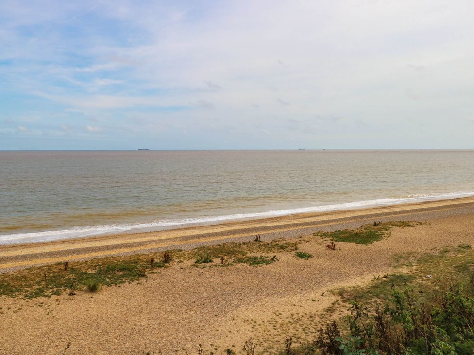 A beach view with sand and water at The Mill House Apartment