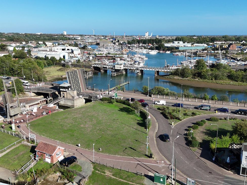 An outdoor view of a marina with boats and a bridge at The Mill House Apartment Oulton Broad