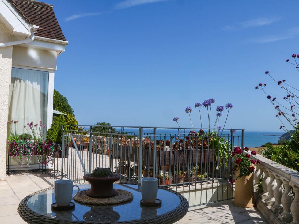 An outdoor area with a table and cups at Elberry Cove View in Paignton