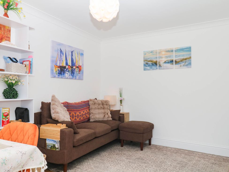 A living room with a sofa and bookshelf at Elberry Cove View Paignton