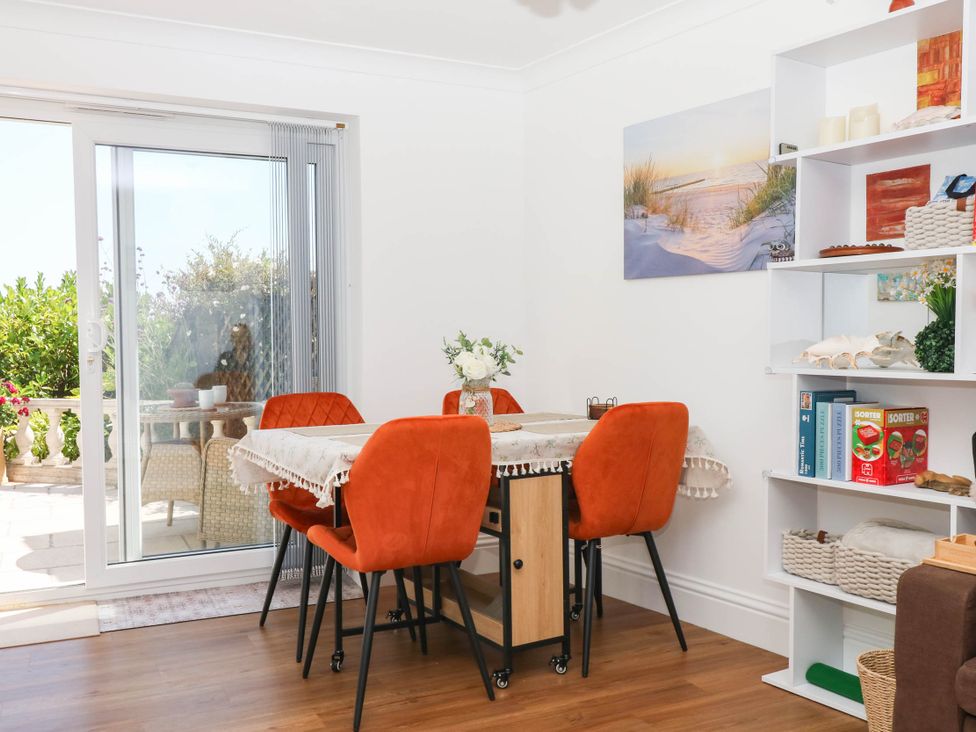 A dining room with a table and chairs at Elberry Cove View in Paignton