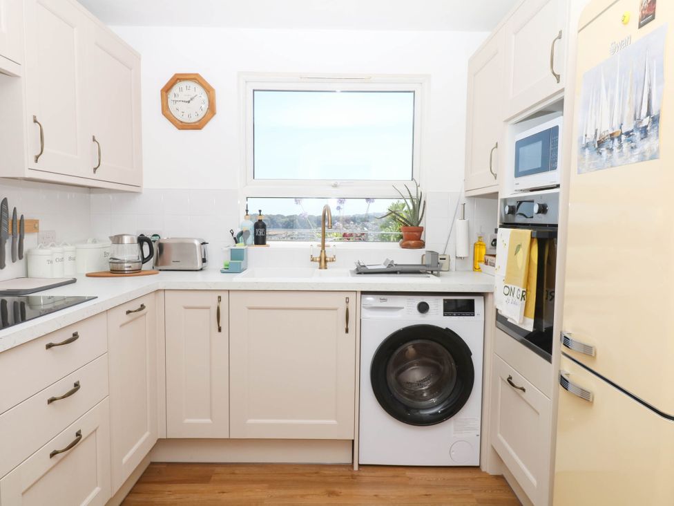 A kitchen with a washing machine and refrigerator at Elberry Cove View in Paignton