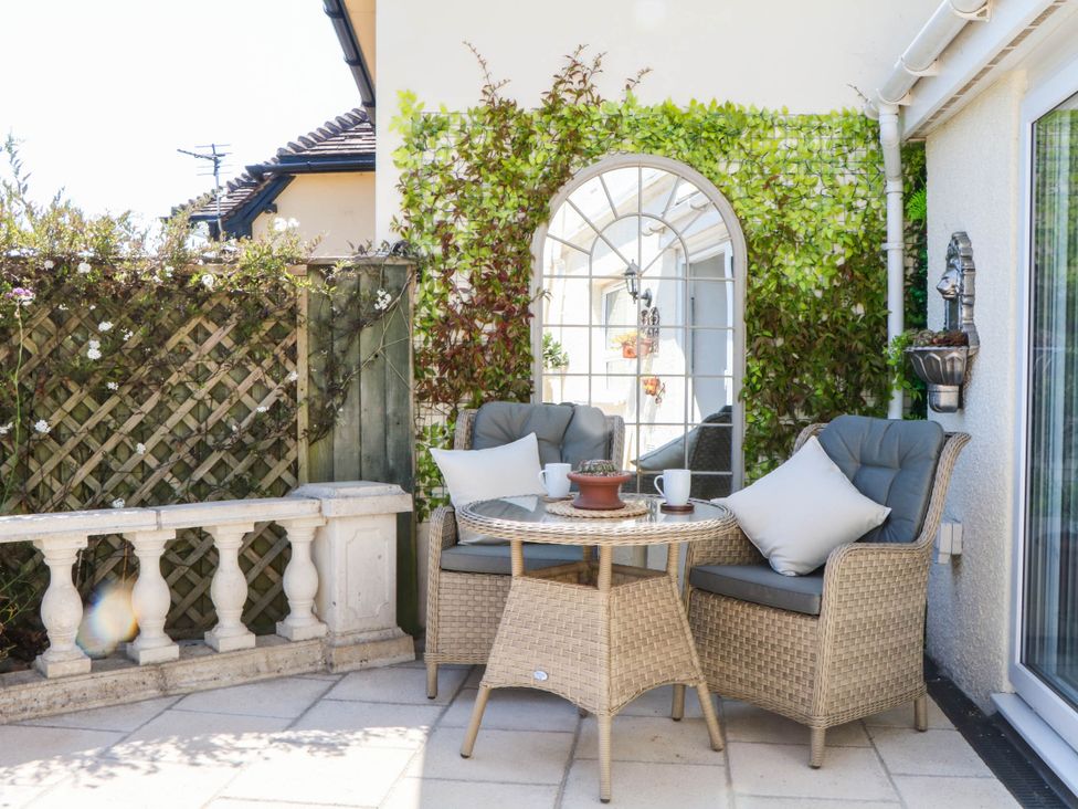 An outdoor seating area with a table and chairs at Elberry Cove View in Paignton