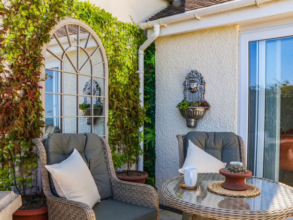 A garden seating area with a mirror and plants at Elberry Cove View Paignton