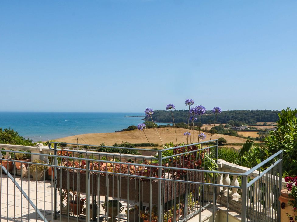 A balcony view of the sea and hills at Elberry Cove View in Paignton