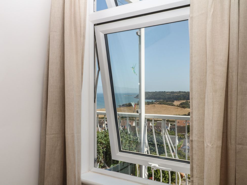 A window showing a view of the sea and landscape at Elberry Cove View in Paignton