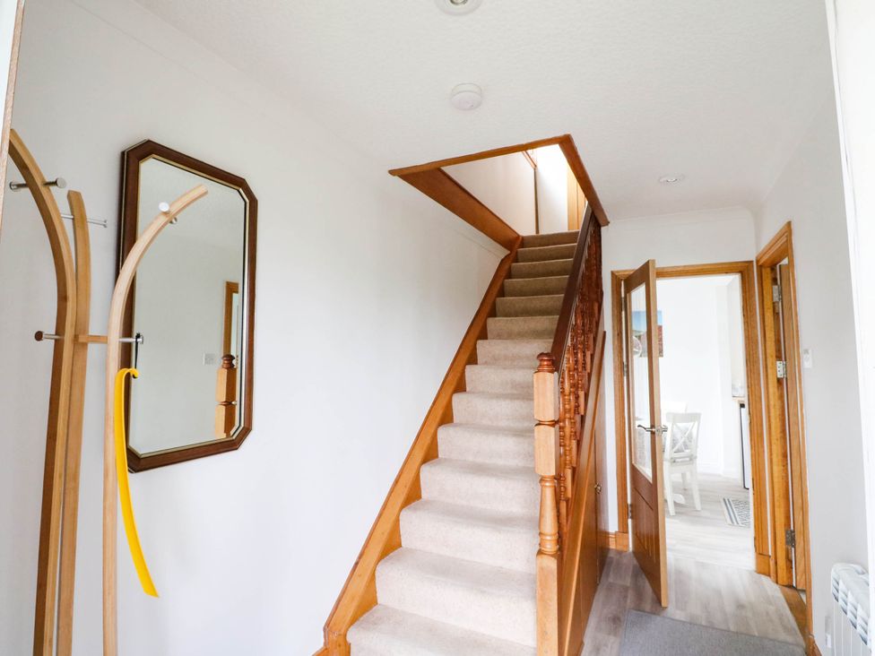 A hallway with a staircase and a mirror at Skye View in Isle of Harris