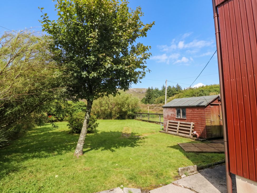 A garden with a tree and a shed at Skye View in Isle of Harris