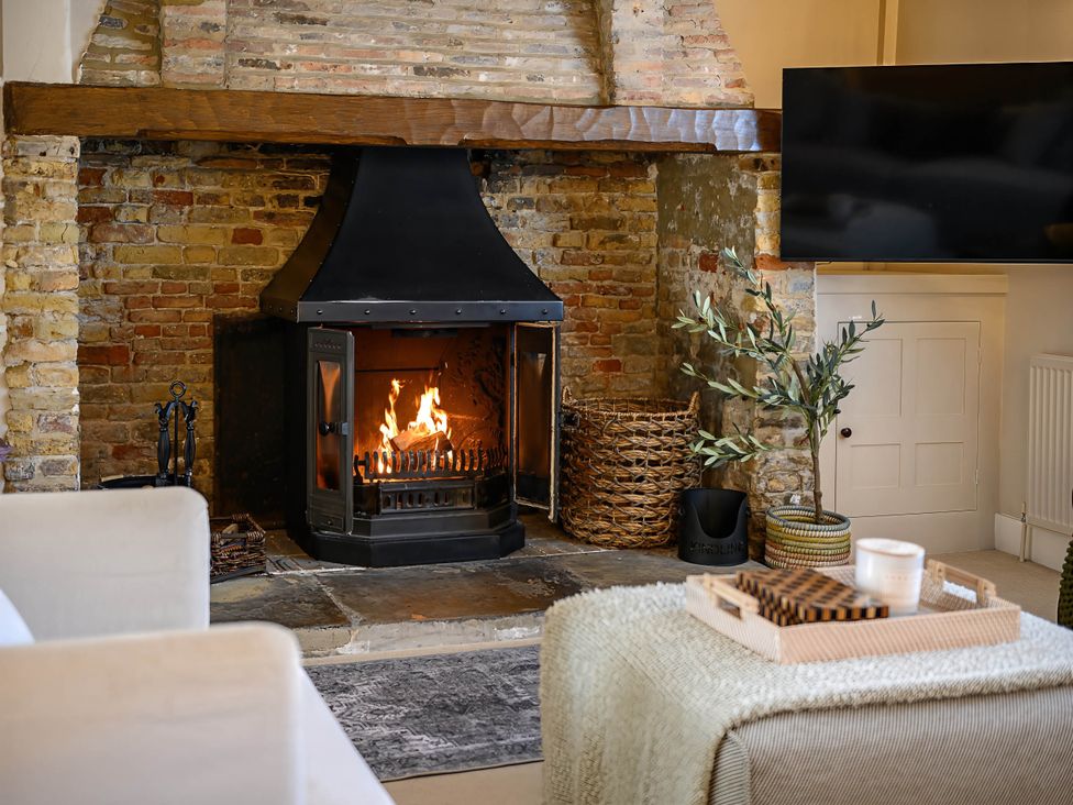 A living room with a fireplace and a television at CobNut Cottage Sandwich