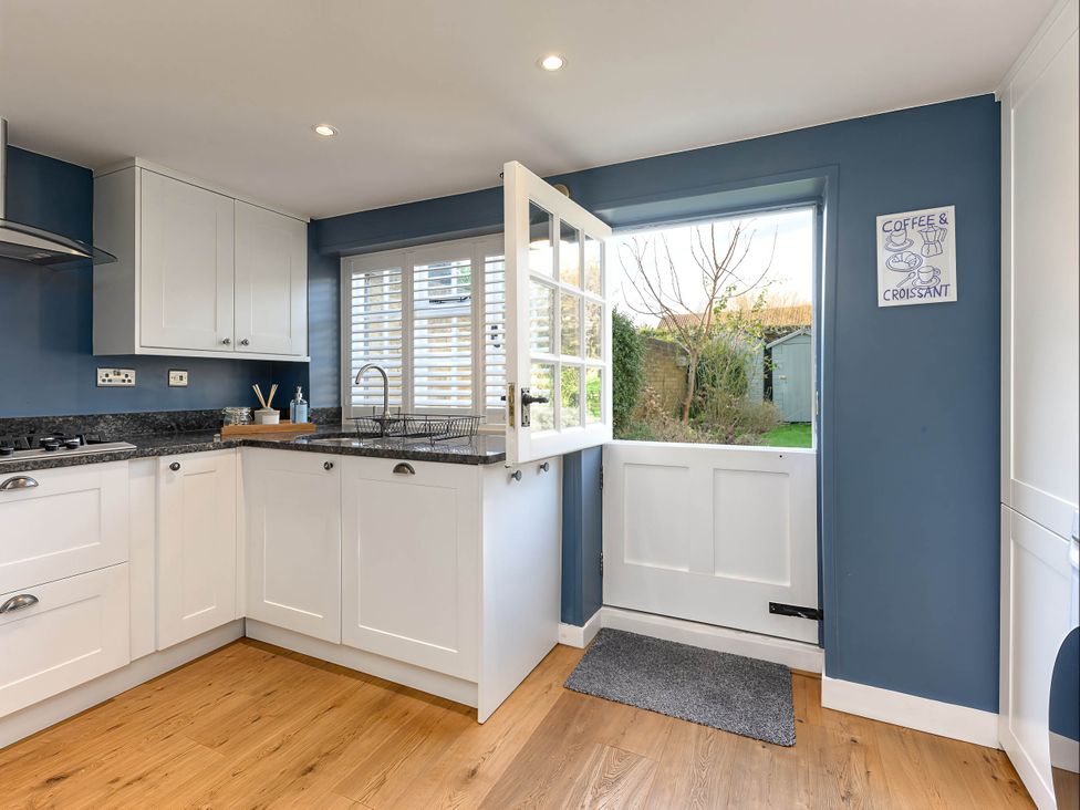 A kitchen with a sink and door to the outside at CobNut Cottage Sandwich