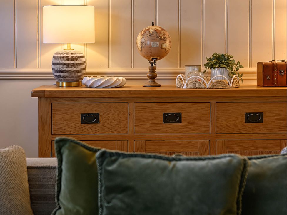 A living room with a sideboard and decorative items at CobNut Cottage in Sandwich