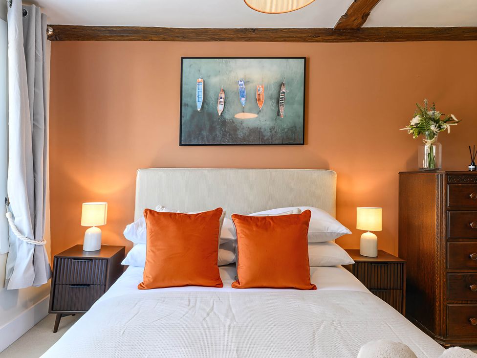 A bedroom with a bed and decorative items at CobNut Cottage in Sandwich