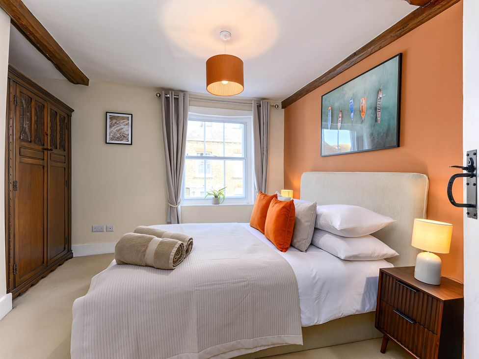 A bedroom with a bed and wardrobe at CobNut Cottage in Sandwich
