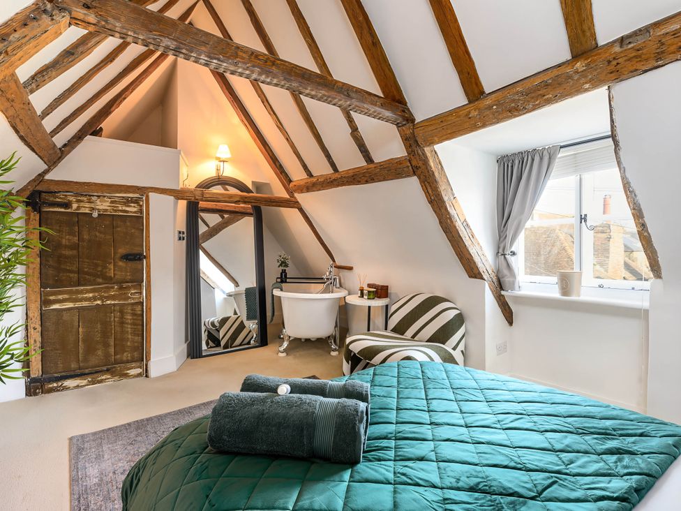 A bedroom with a bed and a bathtub in CobNut Cottage Sandwich