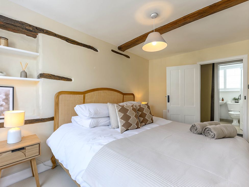 A bedroom with a bed and adjoining bathroom at CobNut Cottage Sandwich