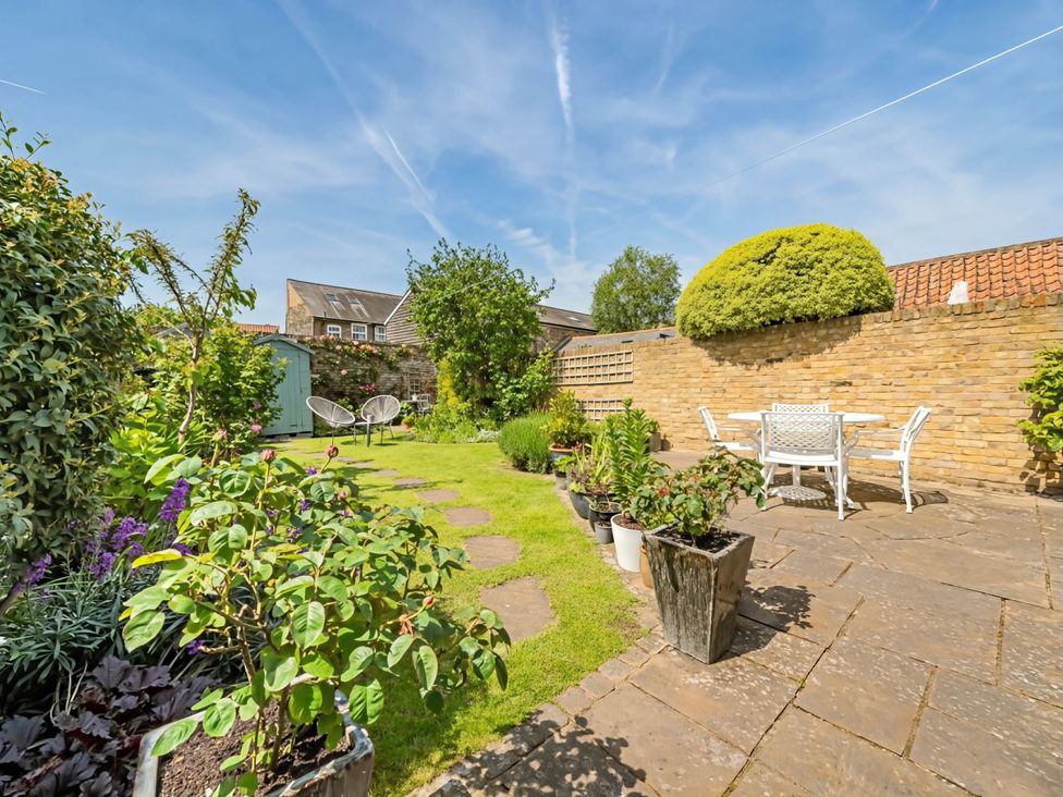 A garden with a table and chairs at CobNut Cottage Sandwich