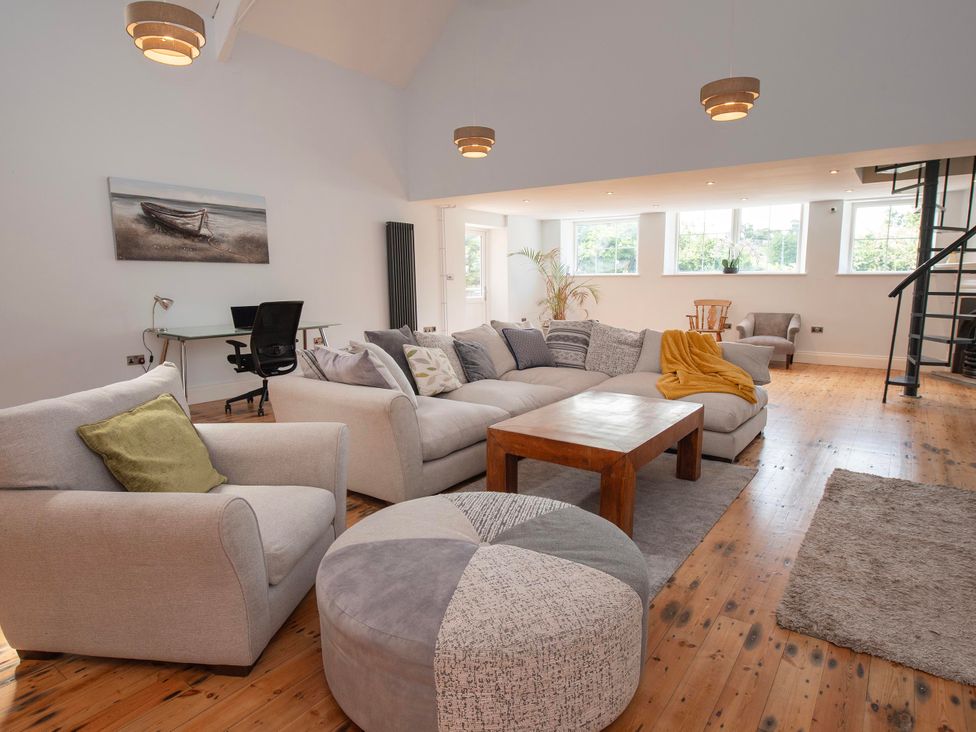 A living room with a sofa, coffee table, and desk at The Old School House