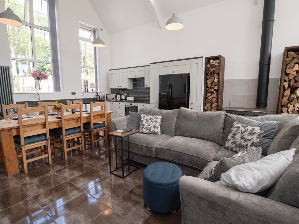 A living room and kitchen area with a sofa and dining table at The Old School House